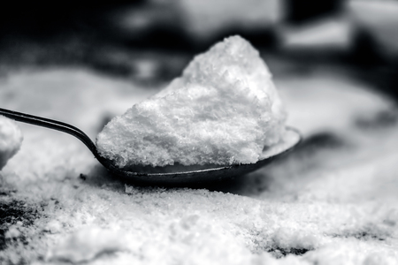 Common salt, Sodium chloride in a wooden scoop on wooden floor. Black and whiteの写真素材