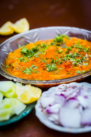 Close up of Dal makhani an Indian meal dish for lunch with sliced cucumber,onions and hari chutney with roti and white Khichdi.の写真素材