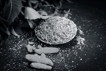 Powder of Indian lilac,Azadirachta indica in a glass plate with its leaves and raw underpowered...