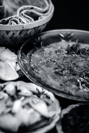Close up of Dal makhani an Indian meal dish for lunch with sliced cucumber,onions and hari chutney with roti and white Khichdi.の写真素材