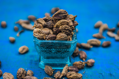 Raw black cardamom on a brownish wooden surface.の写真素材