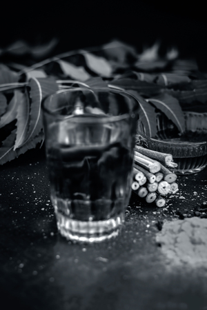 Close up of ingredients of ayurvedic treatment i.e neem,neem leaves,neem powder,bark,clove,turmeric,water.の写真素材