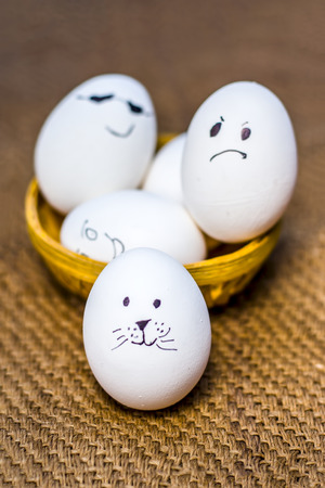 Close up of eggs with funny faces drawn on them.の写真素材