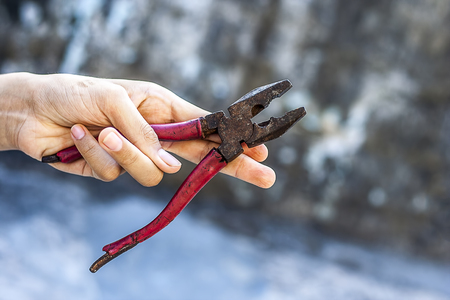 A hand holding  pliers.