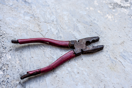 Rusted pliers on rough surface.