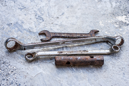 Close up of old rusted tools on a rough surface.