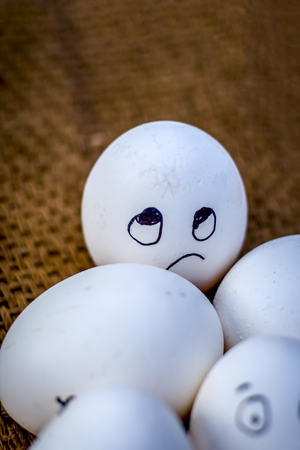 Close up of eggs with funny faces drawn on them.の写真素材