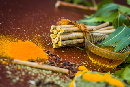 Powder of Indian lilac,Azadirachta indica in a glass plate with its leaves and raw underpowered turmeric.の写真素材