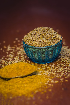 Cumin,Cuminum cyminum and powder on wooden surface.の写真素材