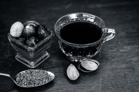 Close up of Nutmeg,Jaiphal,Myristica fragrans in a glass container with its powder and tea in a cup.の写真素材