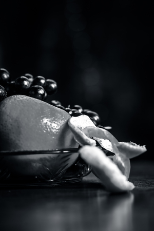 Grape,Vitis vinifera fruit and Oranges,Citrus aurantium in a glass bowl on wooden surface.の写真素材