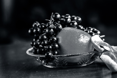 Grape,Vitis vinifera fruit and Oranges,Citrus aurantium in a glass bowl on wooden surface.の写真素材