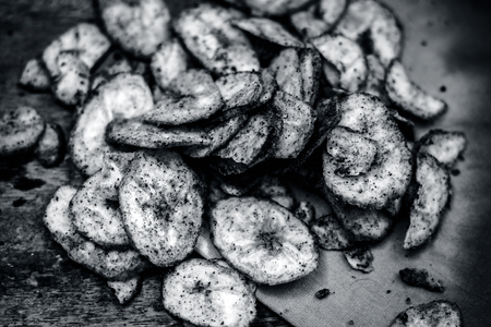 Home made fresh Banana chips on dark wooden surface.  Still life vintage styleの写真素材