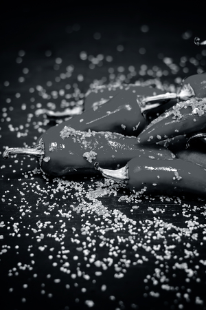 Red chilli pickle marinated in mustard seeds and mustard oil. Dark gothic style still life concept.の写真素材
