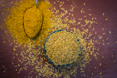 Close up of cumin,Cuminum cyminum and its powder in a spoon on a wooden surface.の写真素材