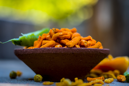 Close up of Indian appetizer, tikha gathiya, bhavnagri gathiya, served as a snacks with green chilly and salad with a cup of tea, cutting chai.の写真素材