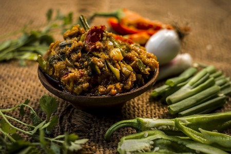Close up of Indian Dish eaten in winter season Baingan ka Bharta with vegetables like:Spring onions,Allium fistulosum,Coriander,Coriandrum sativum,Garlic,Allium sativum and chills.の写真素材