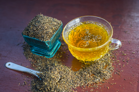 Black cumin seeds,shah jerra,Nigella sativa  and its tea on brown wooden surface.;の写真素材
