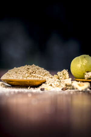 Raw fresh ripe Phyllanthus emblica,amla or Indian gooseberry with its powder on wooden surface.の写真素材