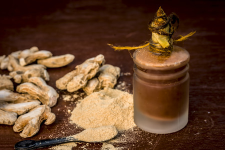 Close up of Extracted oil of dried ginger,Zingiber officinale or soth with raw dried ginger.の写真素材