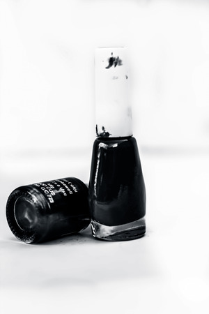 Purple and light ocean blue colored nail polish bottle isolated on a white surface.の写真素材