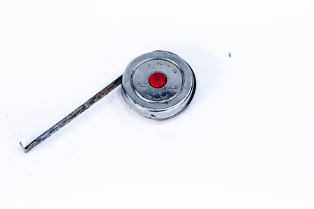 Measuring tape of labors for measuring the various objects isolated on a white.の写真素材