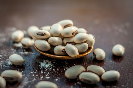 Ayurvedic herb kuanch,cowhage,Mucuna pruriens with powder in a brown plate with its powder and raw kuanch for premature ejaculation, erectile dysfunction and other sperm related diseases.の写真素材