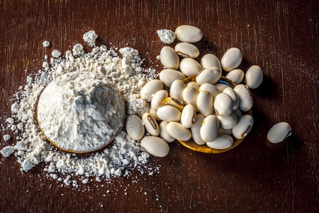 Ayurvedic herb kuanch,cowhage,Mucuna pruriens with powder in a brown plate with its powder and raw kuanch for premature ejaculation, erectile dysfunction and other sperm related diseases.の写真素材