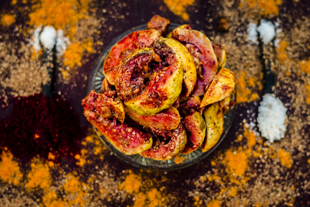 Close up of popular Indian guava pickle or jamrudh ka achar on a wooden surface with raw guava and...