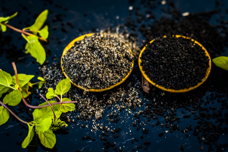Close up of kalonji, Roman coriander, mint leaves, and powder of kalonji with its extracted oil for piles treatment, weight loss, healthy kidney, to low blood pressure etc.の写真素材