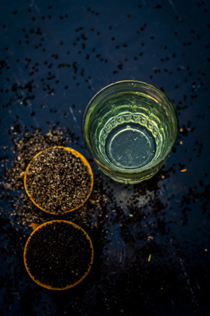 Close up of kalonji or roman coriander with water and honey on wooden surface beneficial for diabetes patient, good in losing weight.の写真素材
