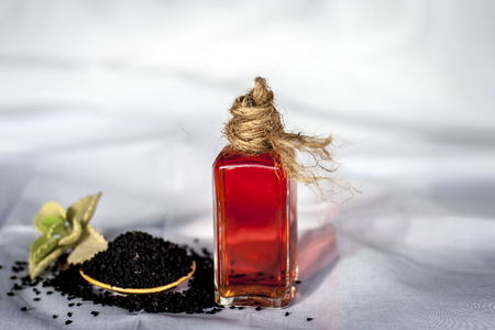 Close up of oil of kalonji with ayurvedic herb ajwain isolated on white used to remove cough and for weight loss.の写真素材