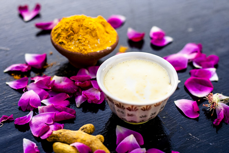 Badam, Haldi & milk ubtan or ayurvedic face maskâs ingredients with ready face pack of Almond with turmeric powder on a black surface removes the dull and black skin.の写真素材