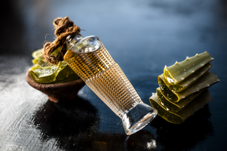 Medicinal and floral essence of Ayurvedic herb Aloe vera with its leaves in a transparent bottle on wooden surface used in many Ayurvedic, Homeopathic, Modern and in Aromatherapyâs medicine.の写真素材