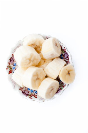 Finely sliced organic banana without skin in a plate peeled skin in side isolated on white.;の写真素材