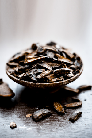 Popular Indian and Asian mukhwas or mouth freshner i.e.  Aam Ki Ghuthli Ka Mukhwas consisiting of ghee and hard boiled mango seeds in a bowl on wooden surface.の写真素材