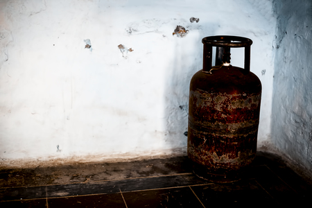 Red colored used  L.P.G gas cylinder on floor.の写真素材