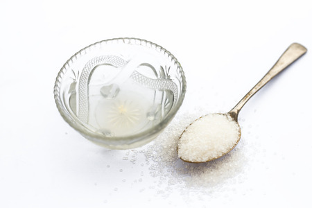 Cube sugar or crystallized sugar with its syrup and mint leaves isolated on white with powder or...