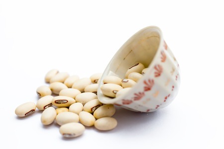 Ayurvedic herb kaunch or velvet bean or bengal velvet bean or Kapikachhu or Mucuna pruriens isolated on white in a glass bowl.の写真素材