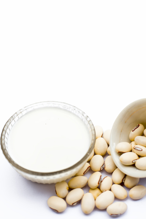Ayurvedic herb kaunch or velvet bean or bengal velvet bean or Kapikachhu or Mucuna pruriens isolated on white in a glass bowl with milk and its powder.の写真素材