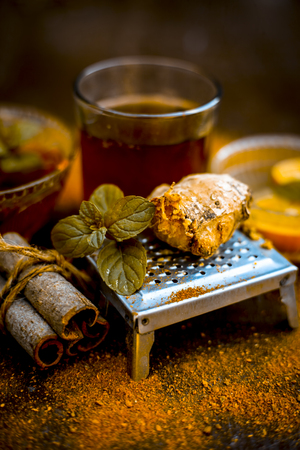 Close up of Ayurvedic home remedy for common cold: Fresh organic ginger ( grated) , warm water, cinnamon stick, honey, and lemon juice.の写真素材