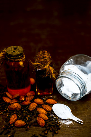 Close up of sea salt, almond oil and clove for alleviation from headache on wooden surface ayurvedic home remedy.の写真素材
