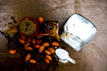 Close up of sea salt, almond oil and clove for alleviation from headache on wooden surface ayurvedic...