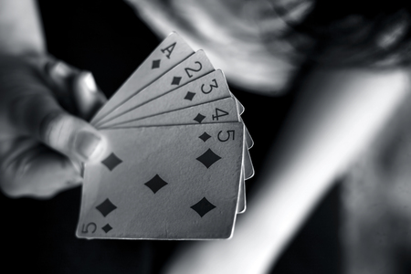 Close up of teenage girl holding a bunch of cards three aces,jacks and kings with queens isolated on...