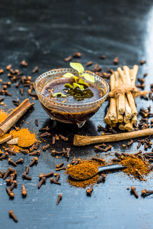 Effective and fiathful home remedy for toothache i.e. Sugar,water,cinnamon stick and whole cloves on wooden surface with neem bark or Indian lilac  bark brushes.の写真素材