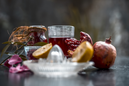 Close up of herbal face pack of pomegranate and lemon juice with rose water on wooden surface with some sliced lemons and pomegranates used for Dull skin.の写真素材