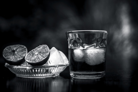 Close up of hangover remedy i.e. lemon juice on wooden surface with Scotch or Scotch whiskey or...