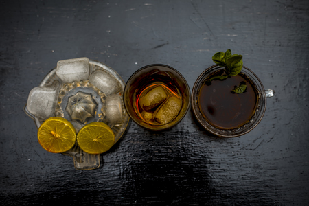 Close up of hangover remedy i.e. lemon juice and black tea in a transparent cup on wooden surface with Scotch or Scotch whiskey or Grain whiskey.の写真素材