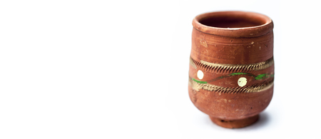 Close up of empty clay glass isolated on white used to serve holy and local drink in it as chass,lassi or golden milk etc.の写真素材