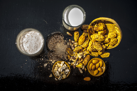 Close up of popular Indian and asian Winter drink on wooden surface i.e. Kharek ka dudh or dried dates milk consisting of milk,dried dates,cashews,almonds dry fruits and sugar.の写真素材